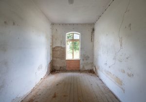 Innenraum mit unverputzten Wänden vor der Sanierung